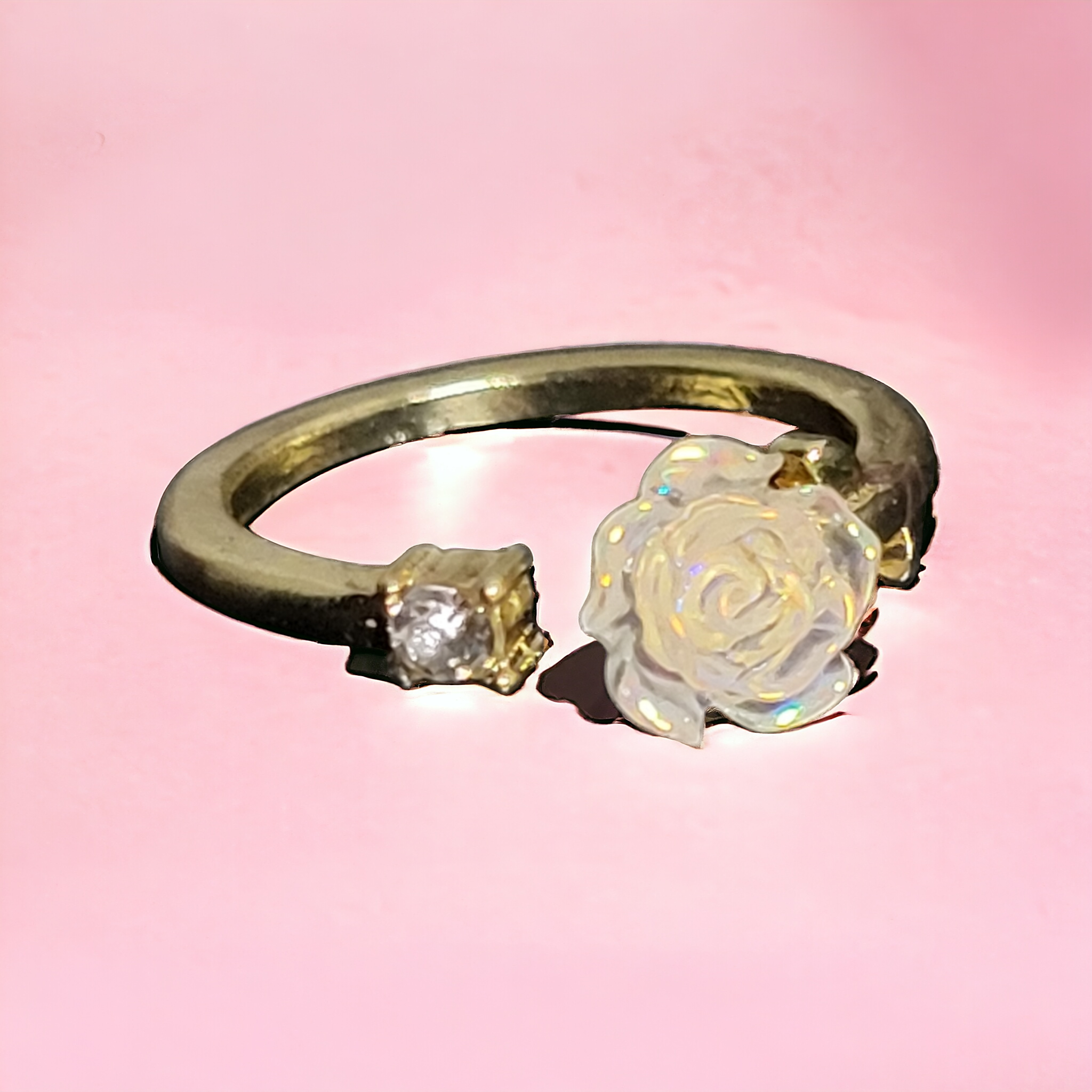 golden ring with a white rose and a stone